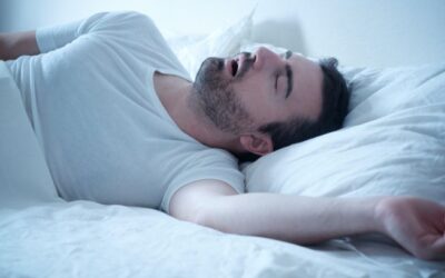 Person experiencing sleep apnea with interrupted breathing and loud snoring during the night