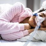 Patient using CPAP machine during sleep apnea treatment to keep airway open