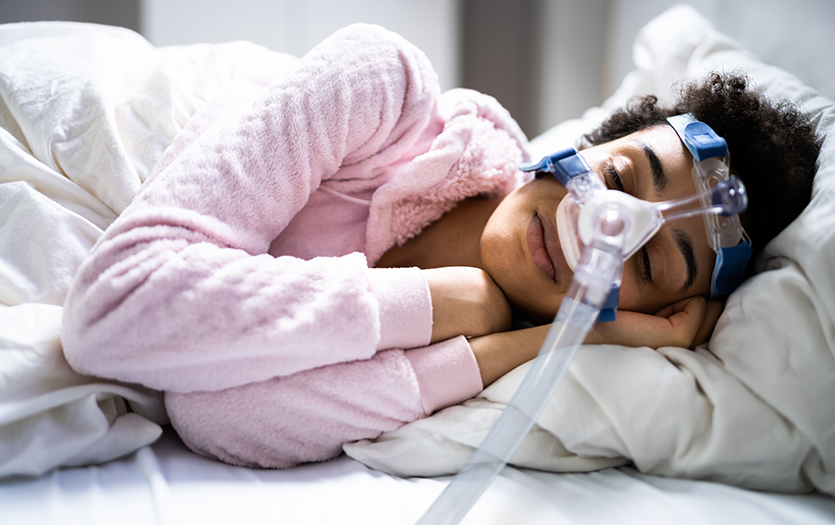 Patient using CPAP machine during sleep apnea treatment to keep airway open